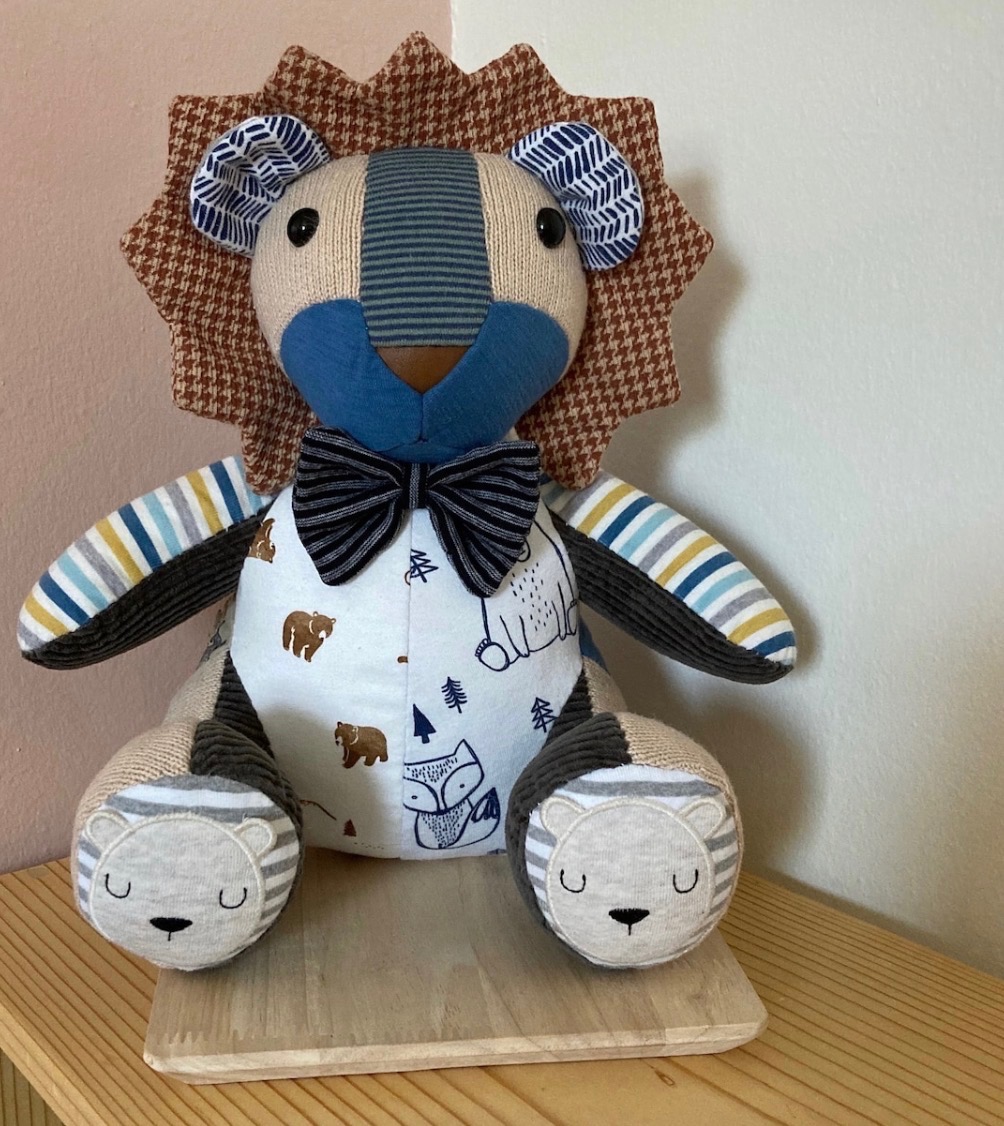 A finished keepsake teddy made from patchwork baby clothes